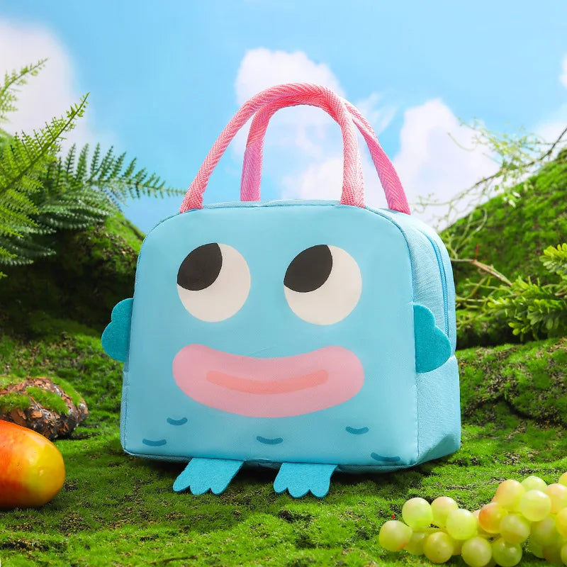Blue kawaii lunch bag with cartoon face design on a grassy background