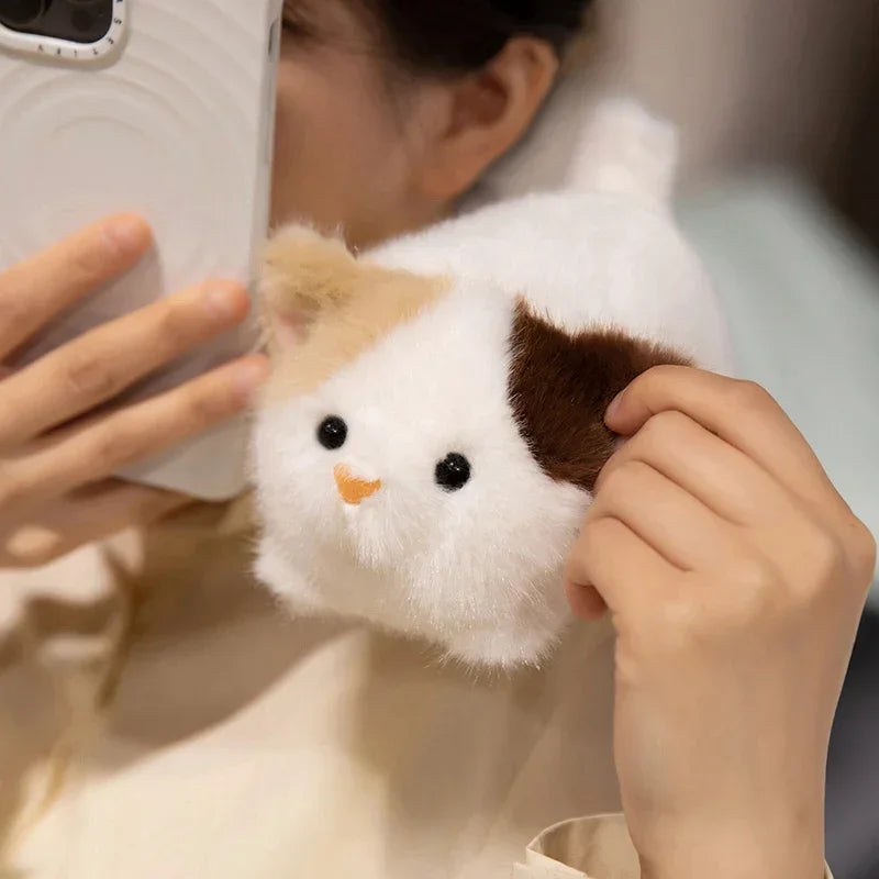 Person holding a small kawaii plush toy resembling a guinea pig.