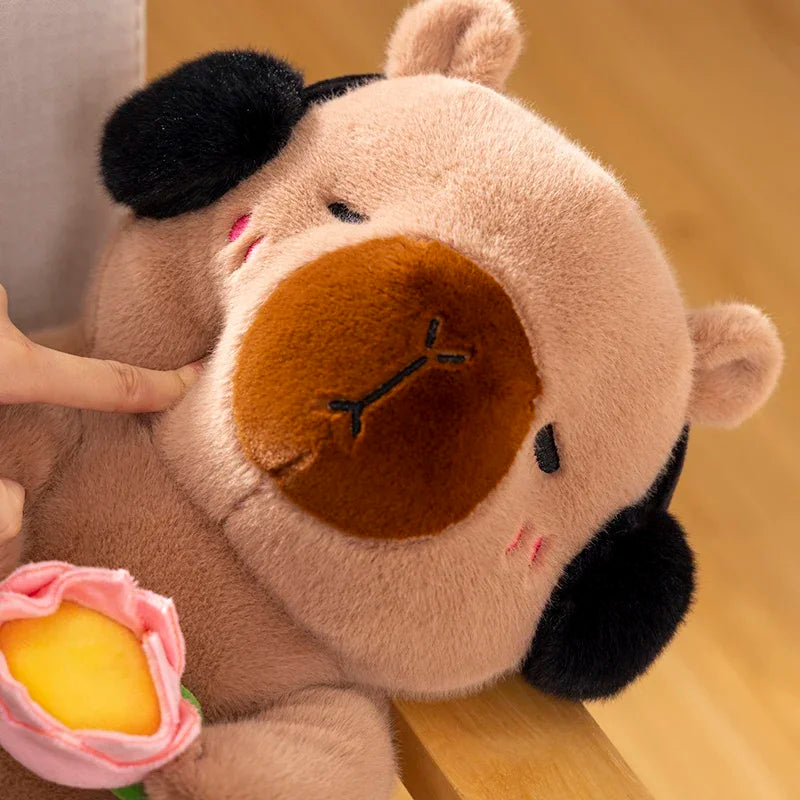 Kawaii plush toy cow with a yellow flower on a wooden surface
