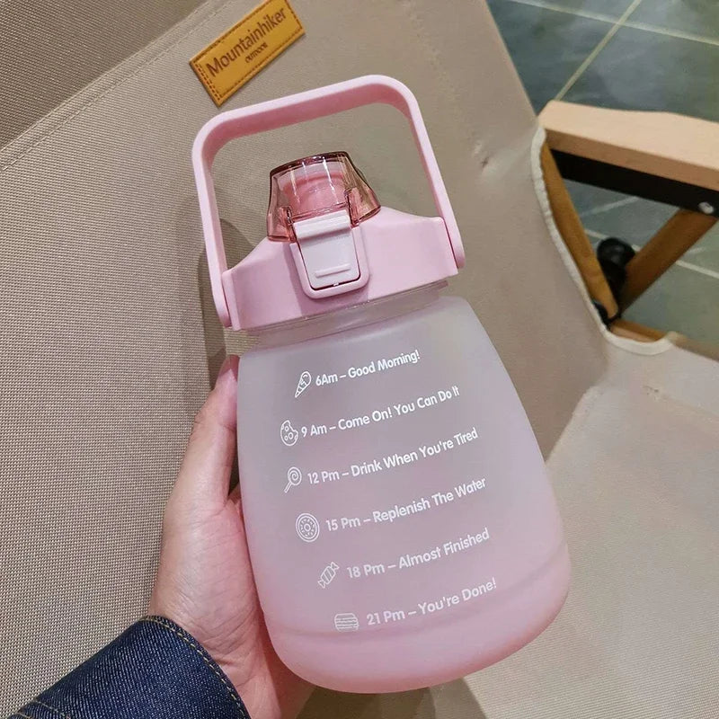 Pink kawaii water bottle with time markings held by a hand, brand 'Mountbello' visible in the background.