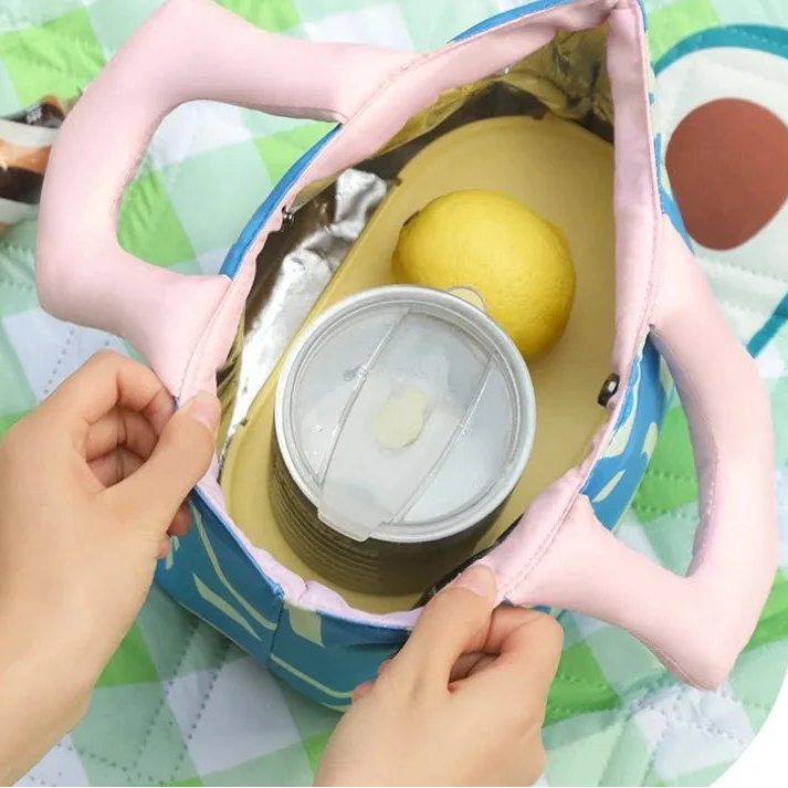 Hands opening a small kawaii lunch bag container with a yellow object inside on a colorful background