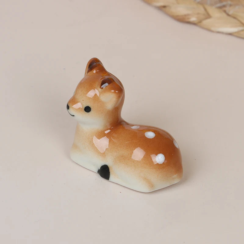 Small ceramic deer kawaii chopstick holders on a beige background