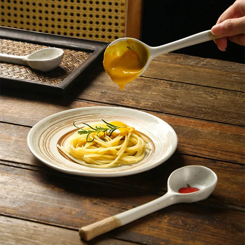 Someone pouring sauce on to pasta while using a kawaii spoon