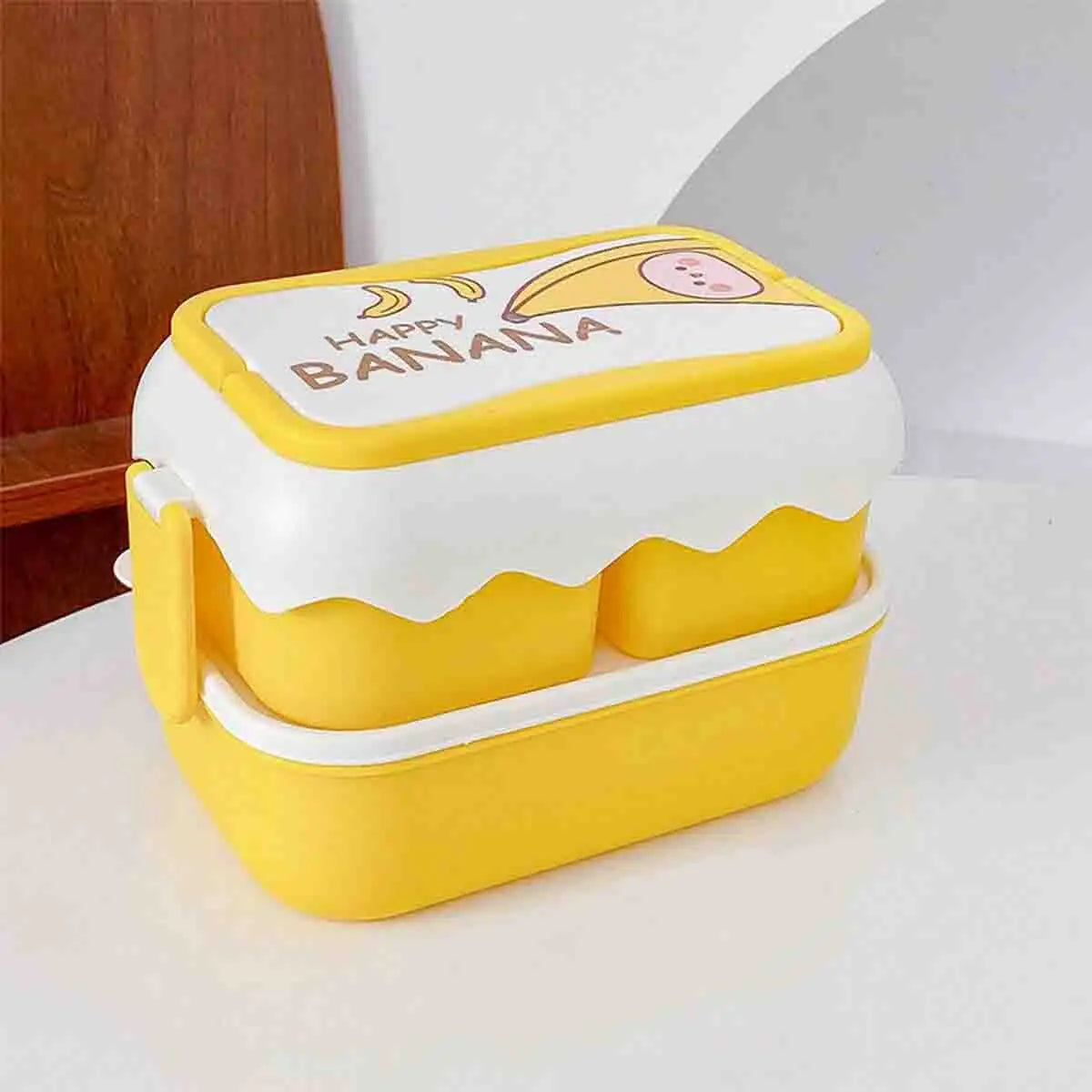Yellow and white kawaii food container with 'Happy Banana' text on a white surface