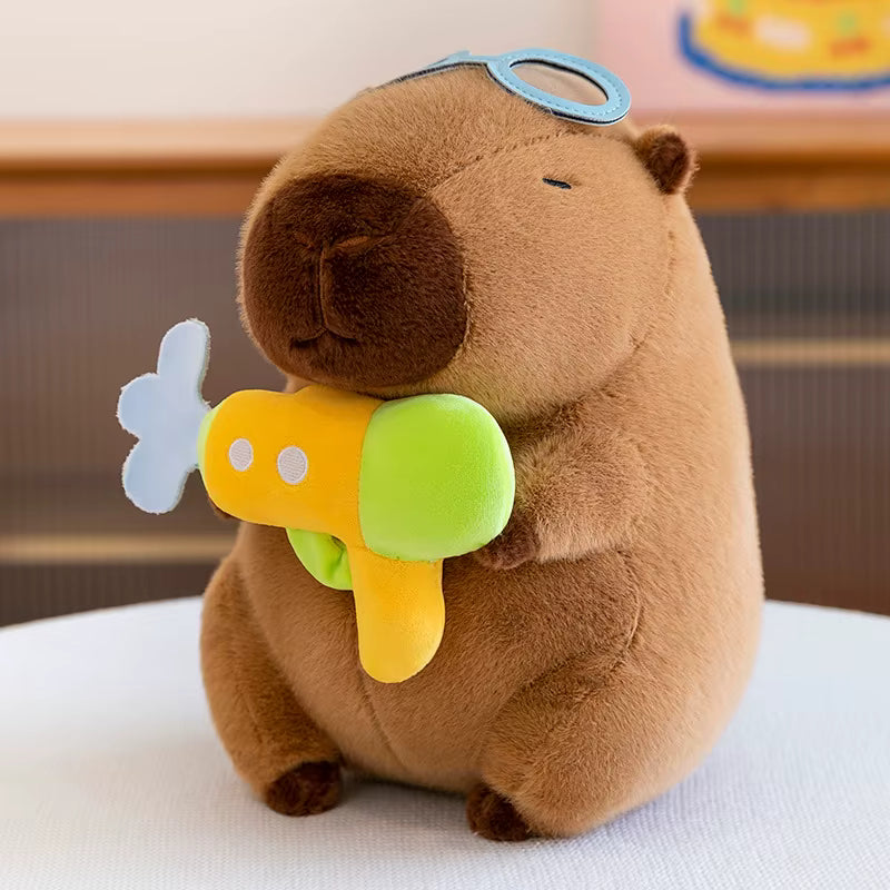 Plush toy resembling a groundhog with a butterfly and flower on a white surface
