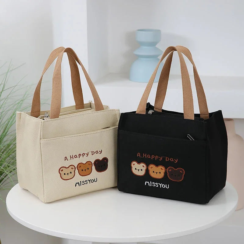 Two kawaii tote bags, one beige and one black, with bear illustrations and text on a white surface.