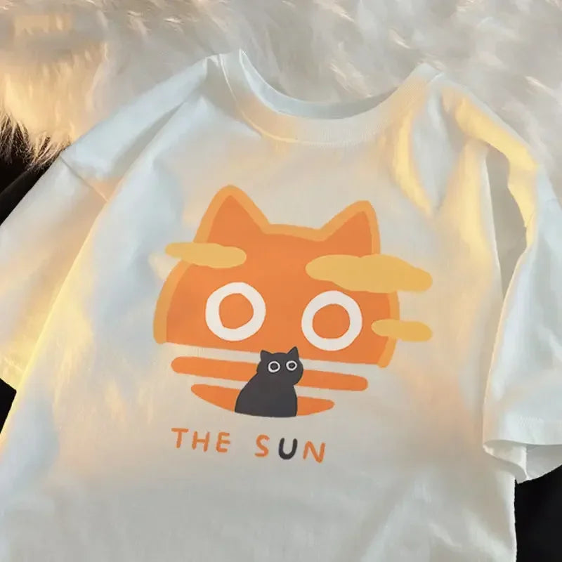 White t-shirt with a kawaii cartoon cat design labeled 'The Sun' on a blurred background
