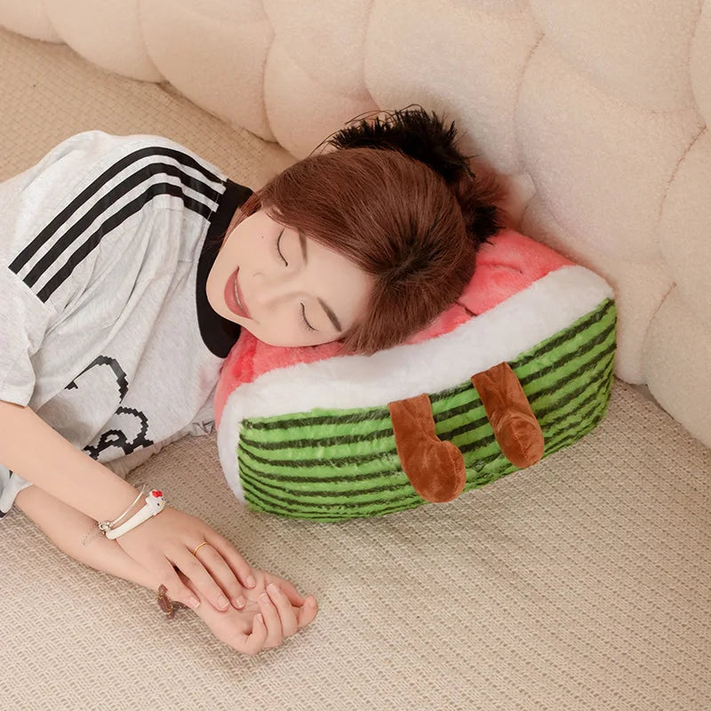 Person lying on a kawaii cushion shaped like a watermelon with a smiling expression.