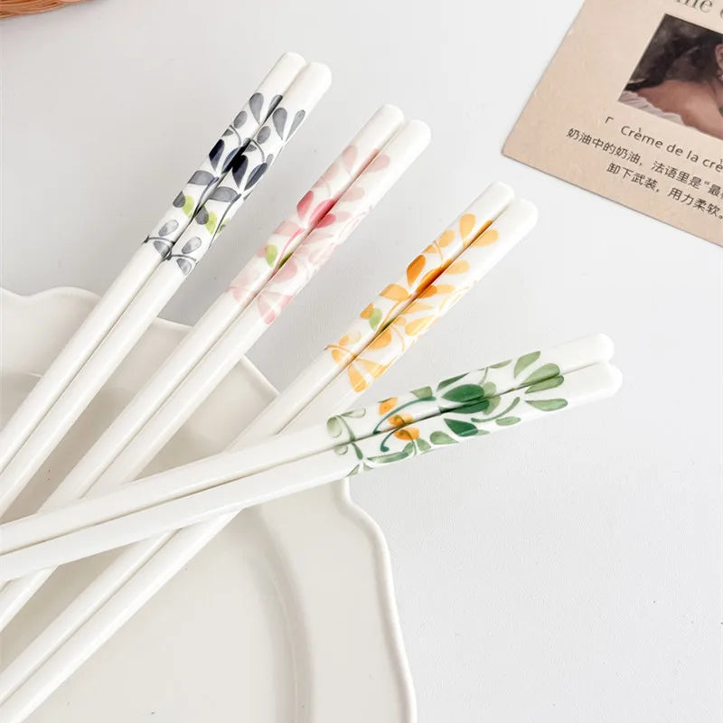 Set of decorative kawaii chopsticks with floral designs on a white surface