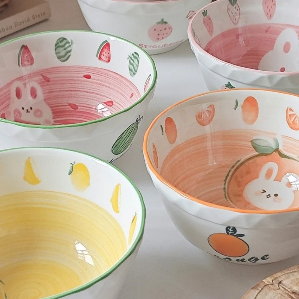 Set of colorful ceramic kawaii ramen bowls with fruit and animal patterns on a white surface.