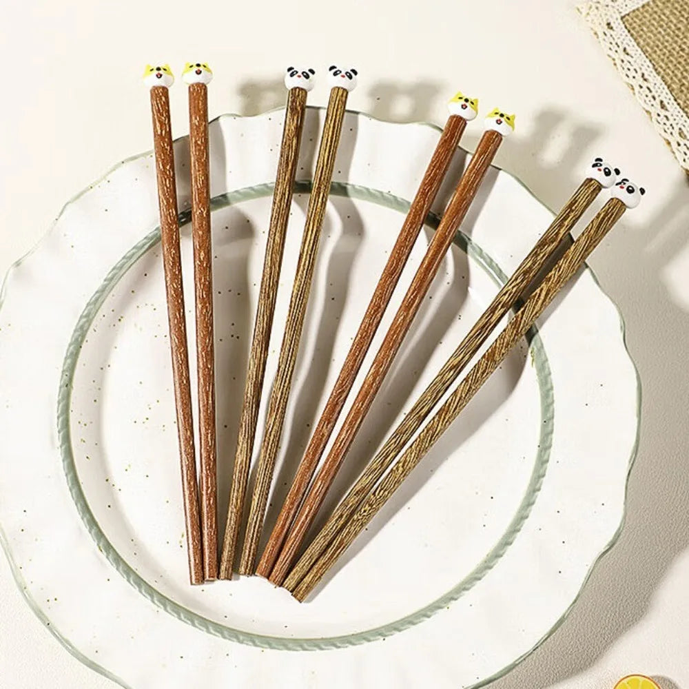 Set of wooden kawaii chopsticks on a white plate with a textured surface