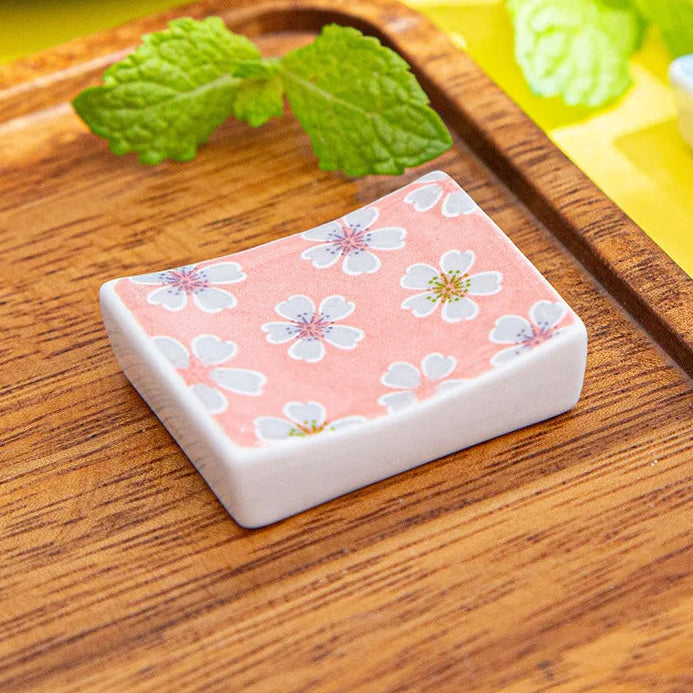 Rectangular kawaii chopstick holders with floral design on a wooden surface