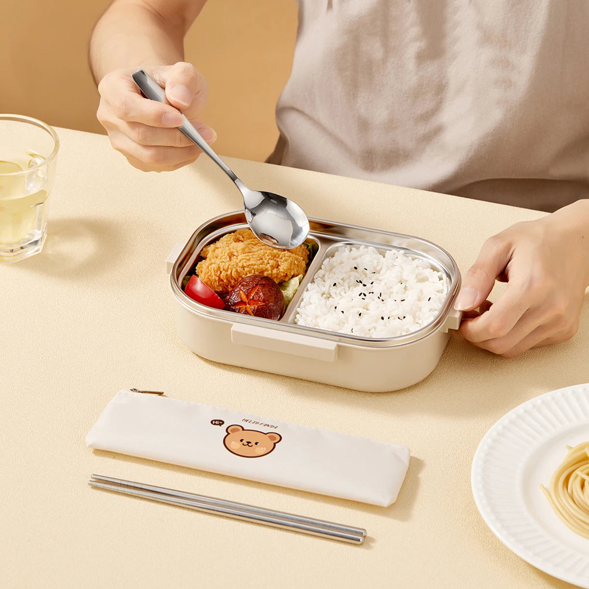 Person eating from a bento box with kawaii utensils.