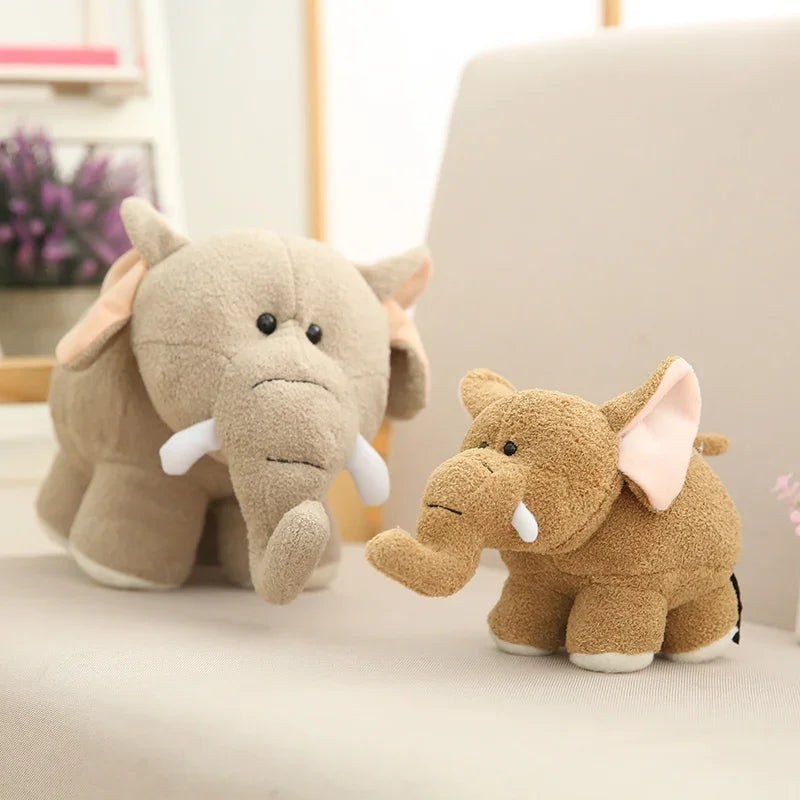 Two kawaii plush elephant toys on a light surface with a blurred background