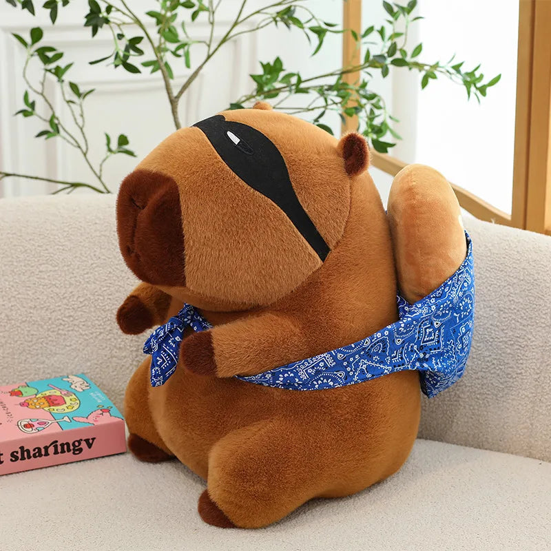Kawaii plush toy dog wearing a blue bandana on a couch with a plant in the background