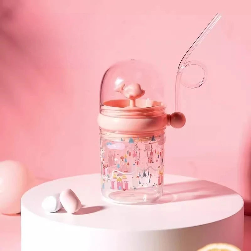 Clear kawaii cup with pink lid and straw on a white platform against a pink background