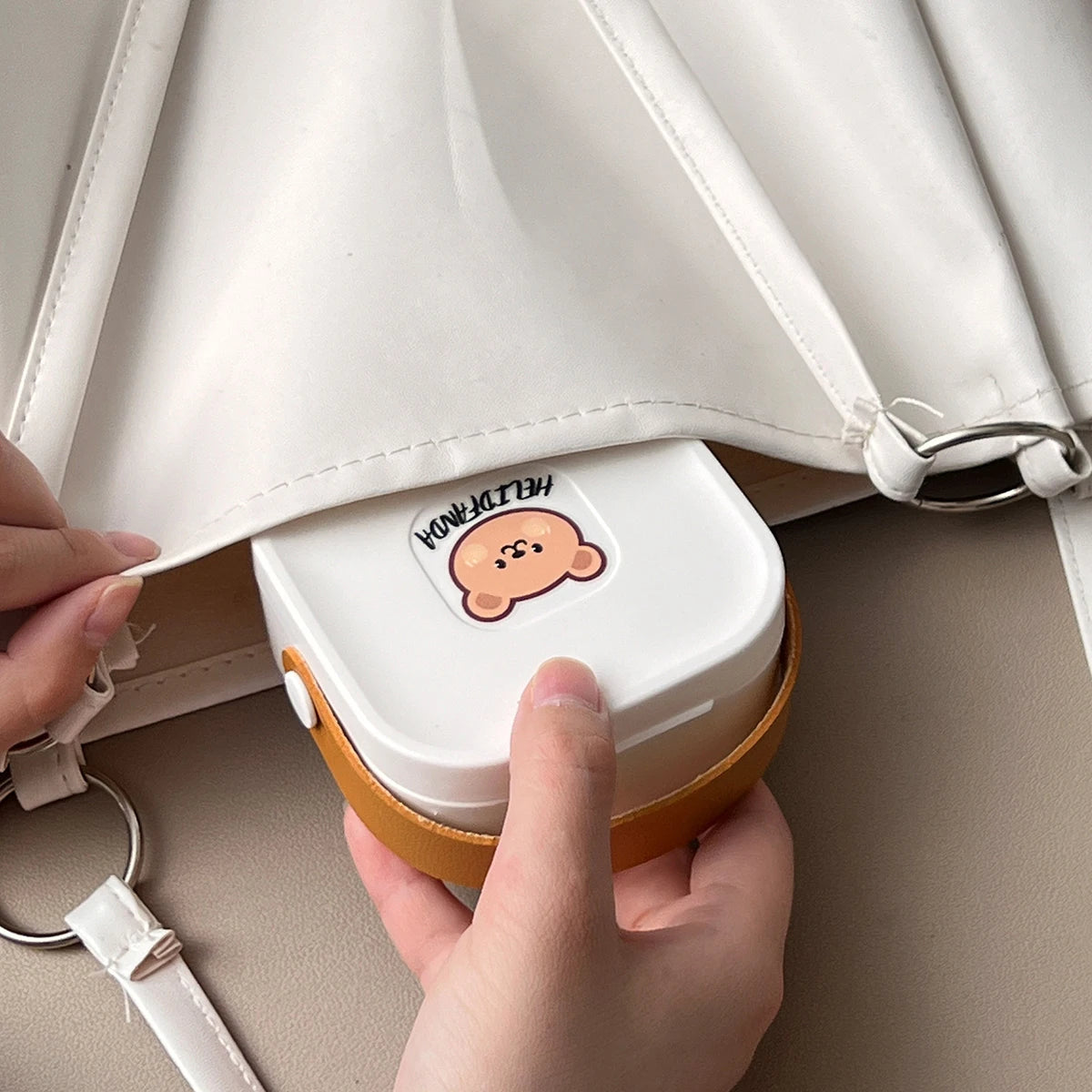 Someone placing a set of kawaii utensils into a bag