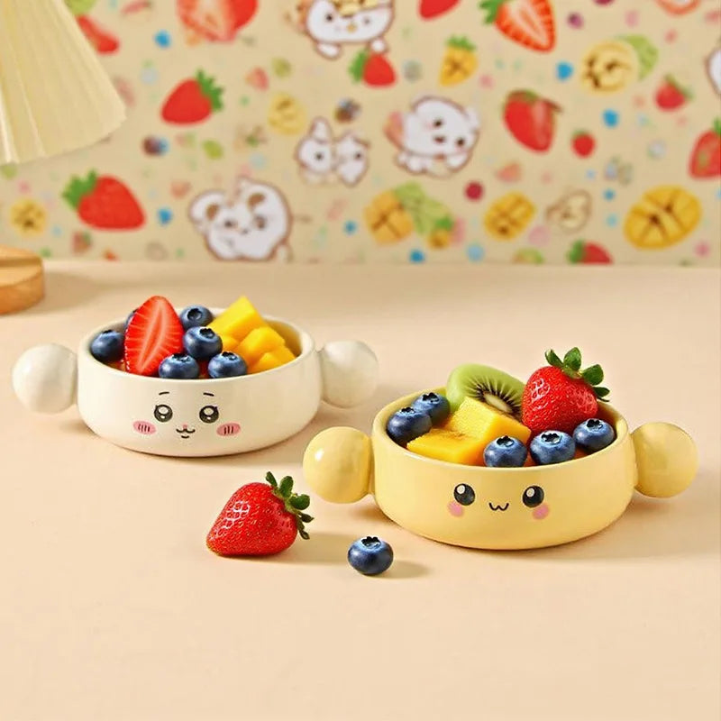 Two cute, cartoon-style kawaii ramen bowls filled with fruits on a matching yellow background.