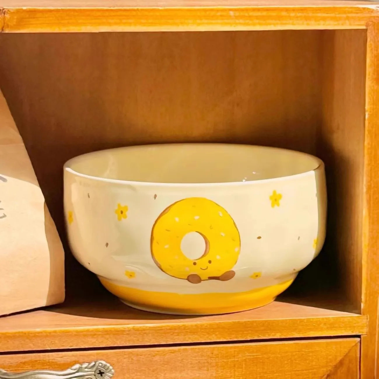 A kawaii bowl with a yellow donut on it