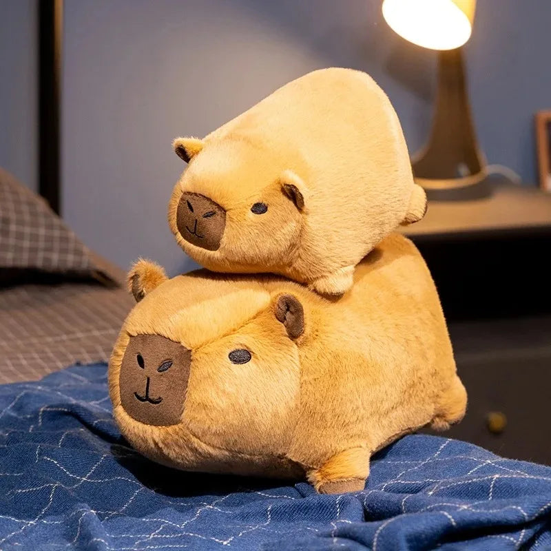 Two brown kawaii plush toys stacked on top of each other on a blue blanket.