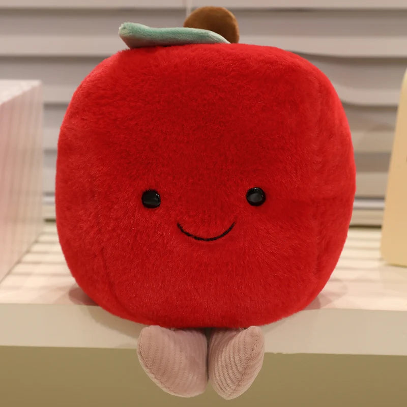 Kawaii plush toy shaped like a red apple with a smiling face on a shelf.