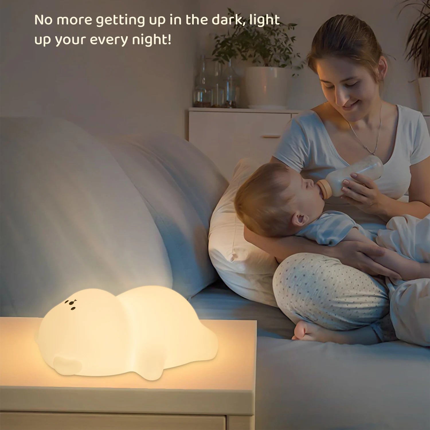 Woman feeding a baby with a kawaii night light on a bedside table.