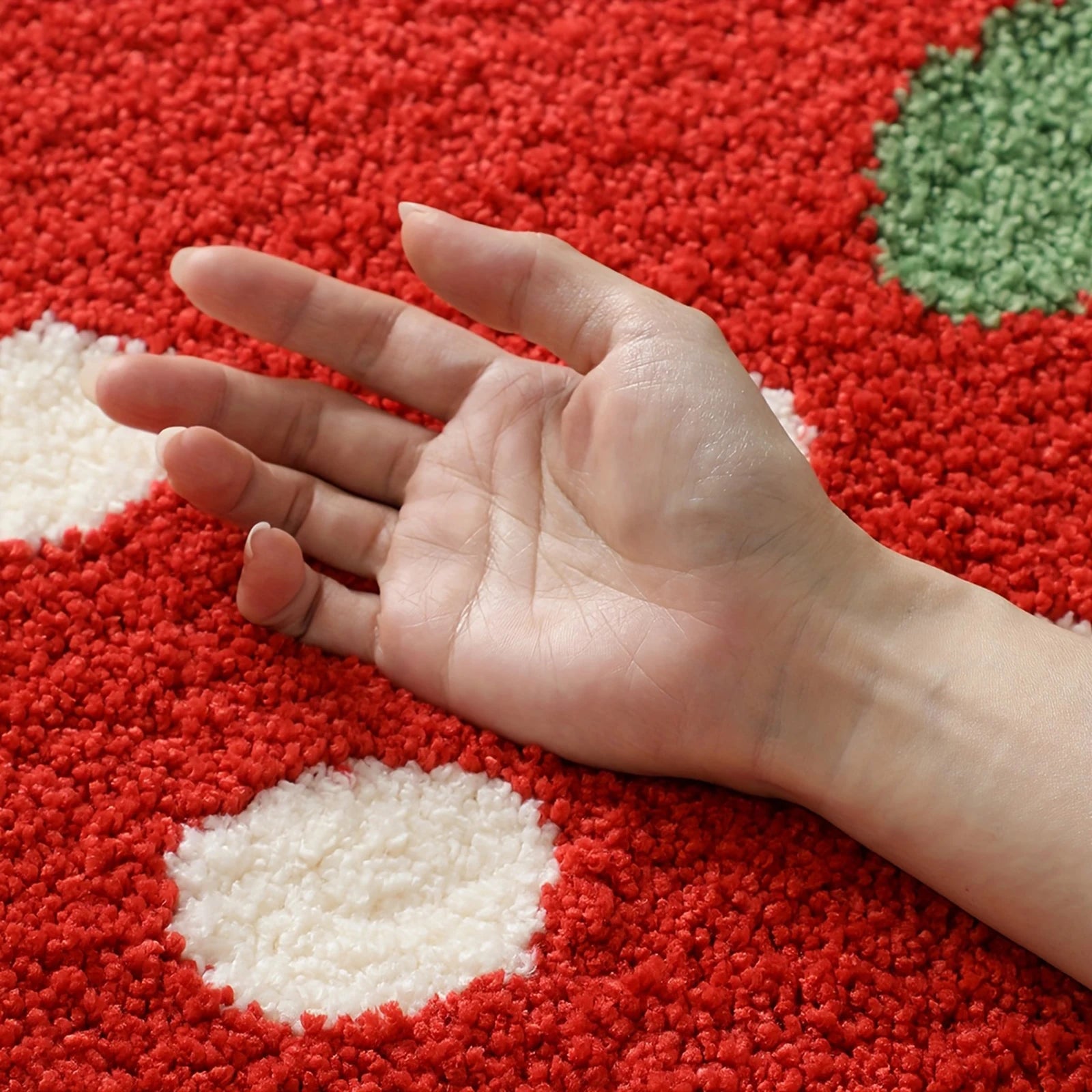 Hand on a red textured kawaii rug with white and green shapes