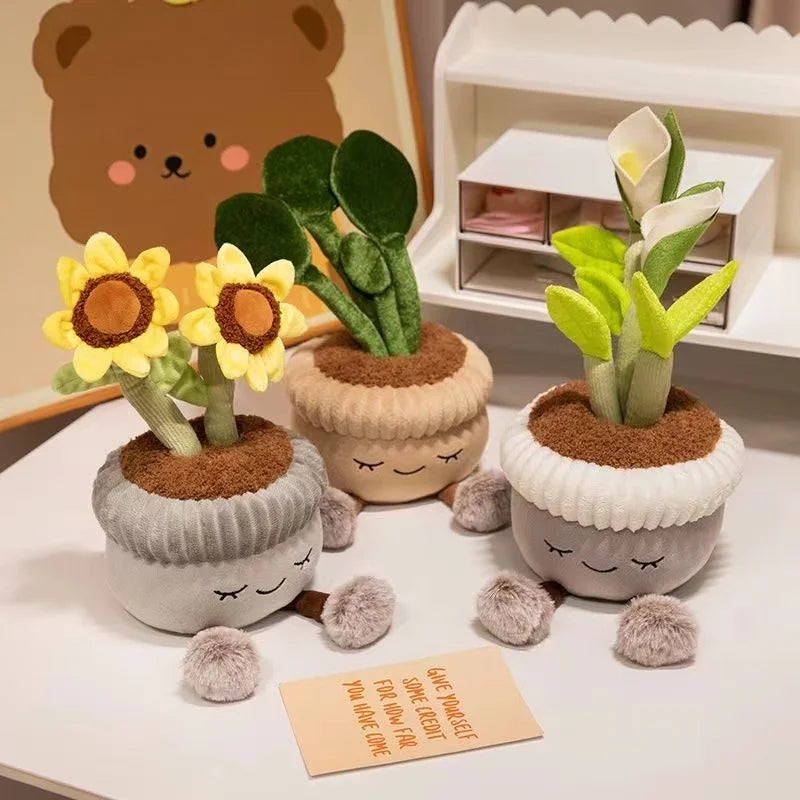Plush kawaii plants in pots with smiling faces on a white surface, with a bear plush toy in the background.