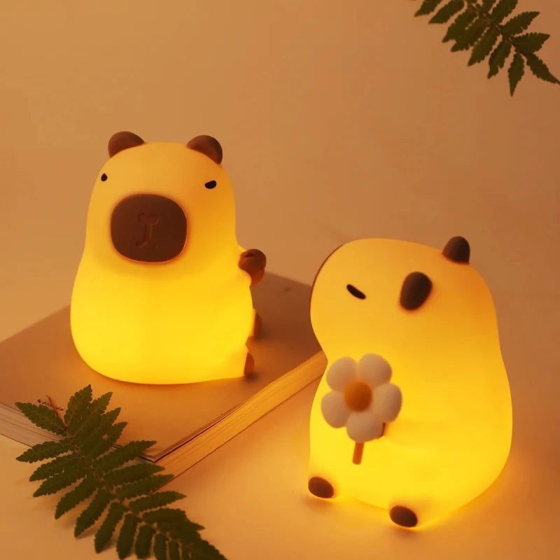 Two cute animal-shaped night lights on a surface with a soft, warm glow.