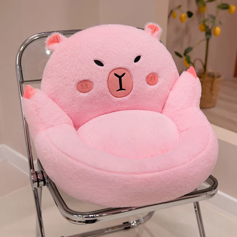 Pink bear-shaped kawaii cushion on a chair with a blurred indoor background
