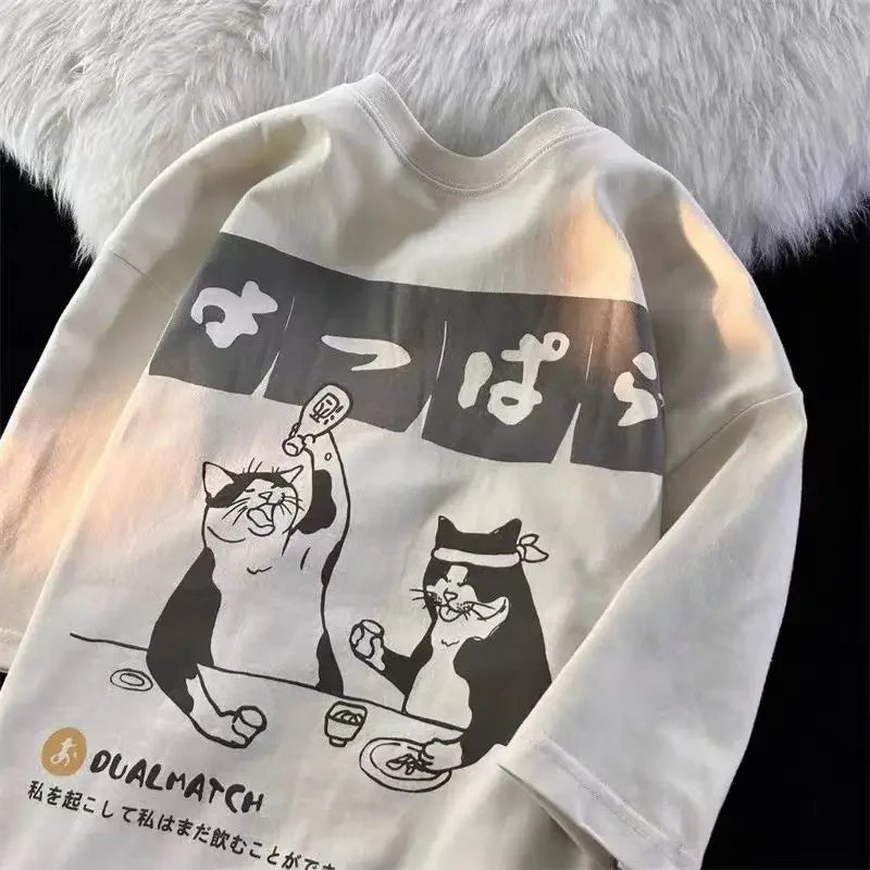 White sweatshirt with kawaii black and white cat graphic and text on a fluffy white background