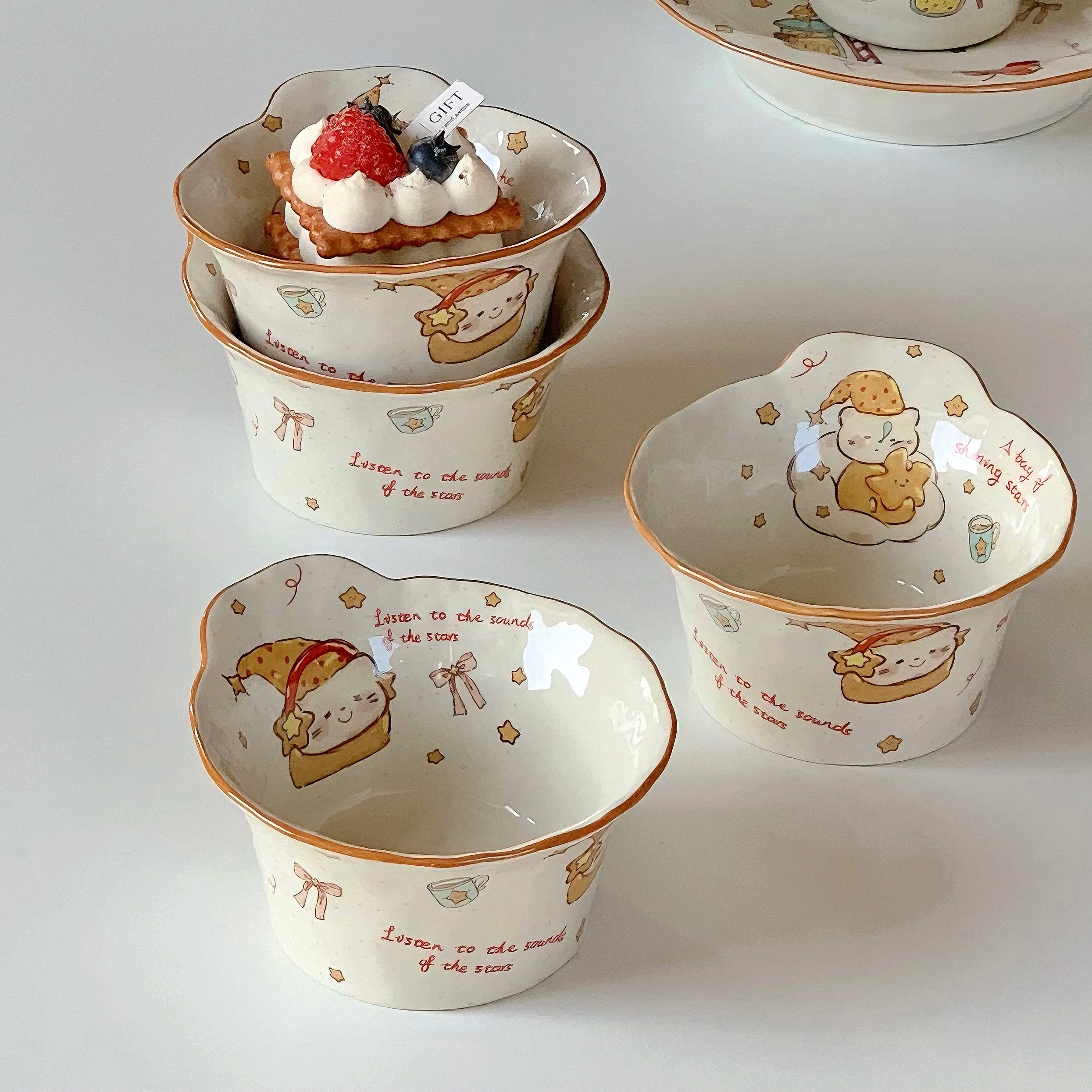 Set of small ceramic kawaii ramen bowls with cartoon character designs on a white surface