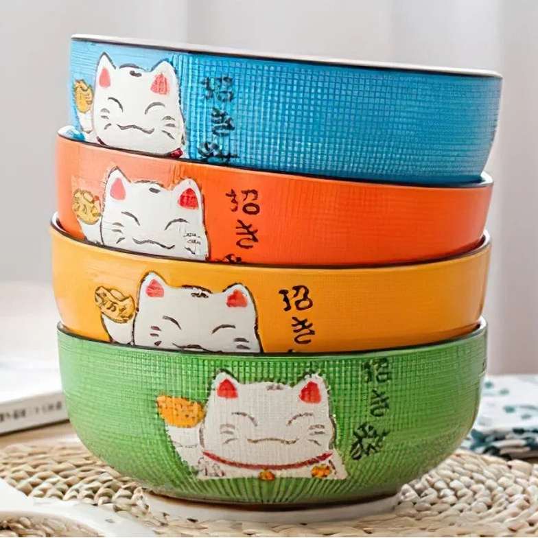 Set of four colorful kawaii bowls with a cat design on a textured surface.