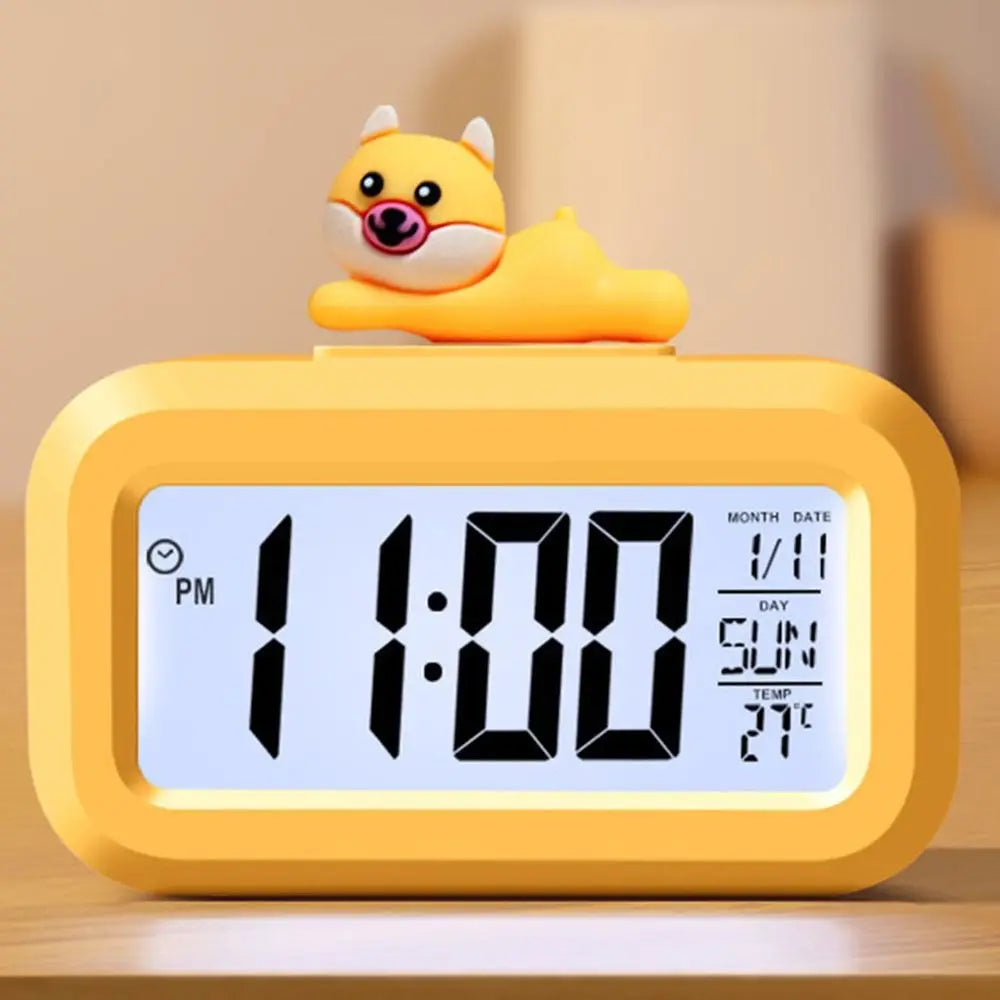 Yellow kawaii digital clock with a cartoon character on top, displaying the time and date.