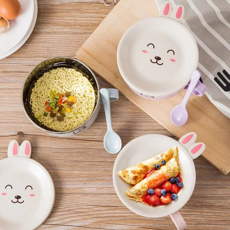 Children's kawaii ramen bowls with cartoon faces, one containing noodles and another with an omelette and fruit on a wooden table.