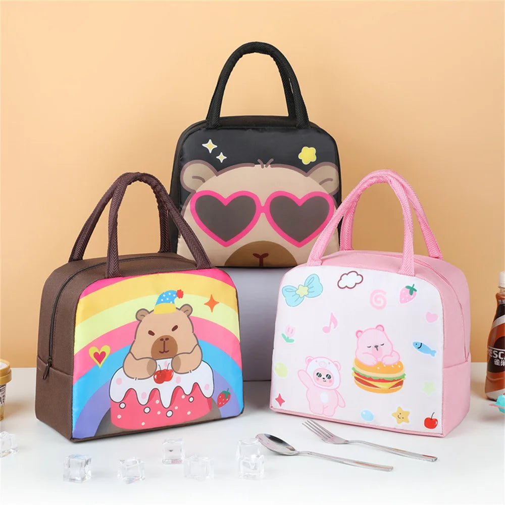 Three cartoon-themed kawaii lunch bags on a white surface with a beige background