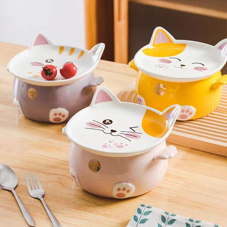 Three cat-shaped ceramic kawaii ramen bowls with lids on a wooden table.