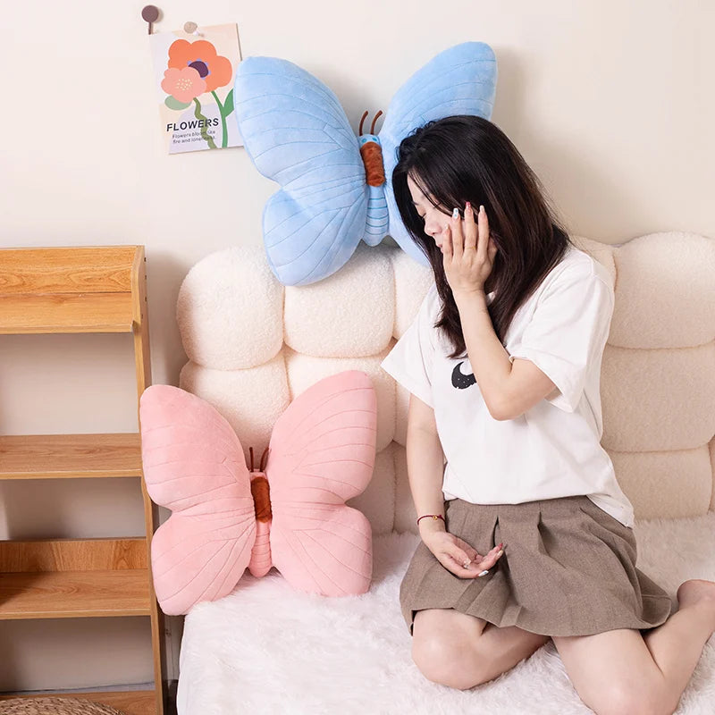 Woman sitting on a kawaii couch with butterfly-shaped pillows in pink and blue.