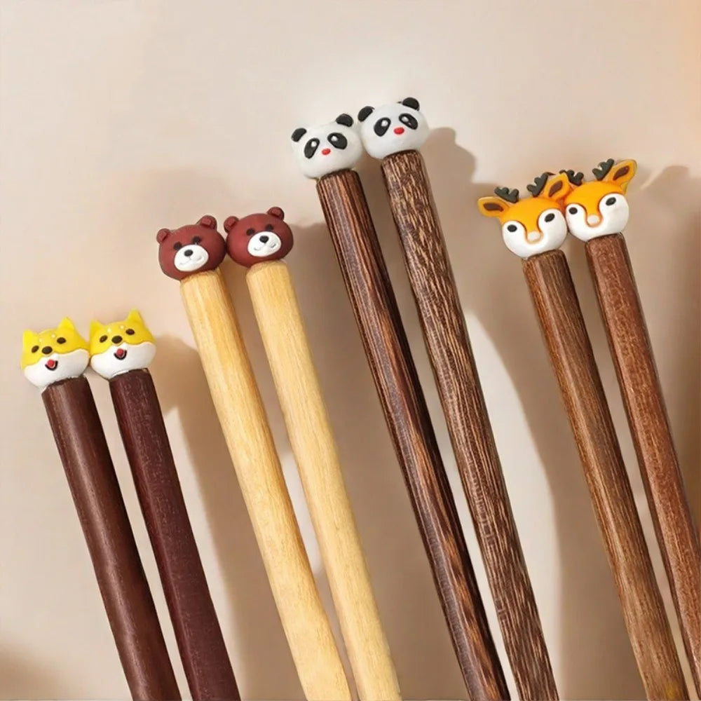 Set of kawaii chopsticks with animal-themed ends on a beige background