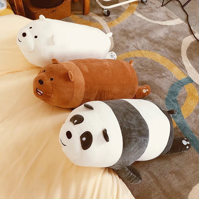 Three kawaii plush toys shaped like a panda, hippo, and seal on a bed with a colorful rug.