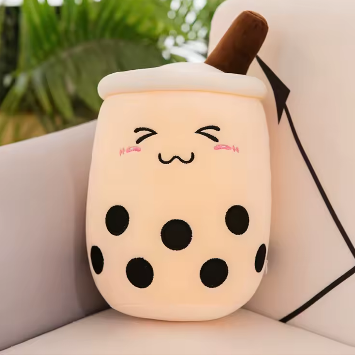 Kawaii plush toy shaped like a bubble tea cup with a face on a couch