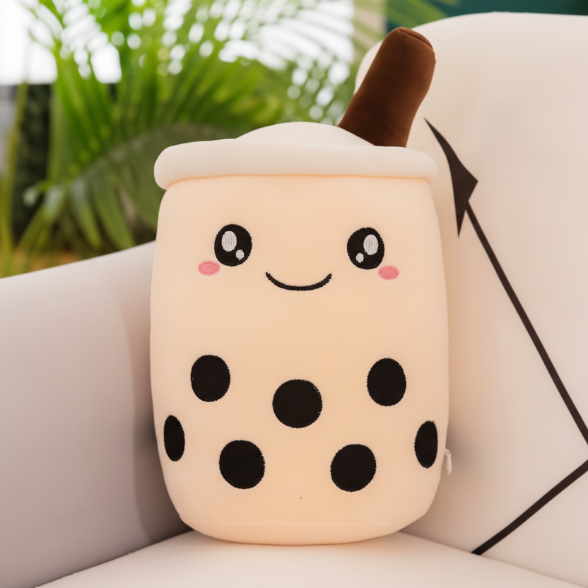 Kawaii plush toy resembling a bubble tea cup with a happy face on a couch.
