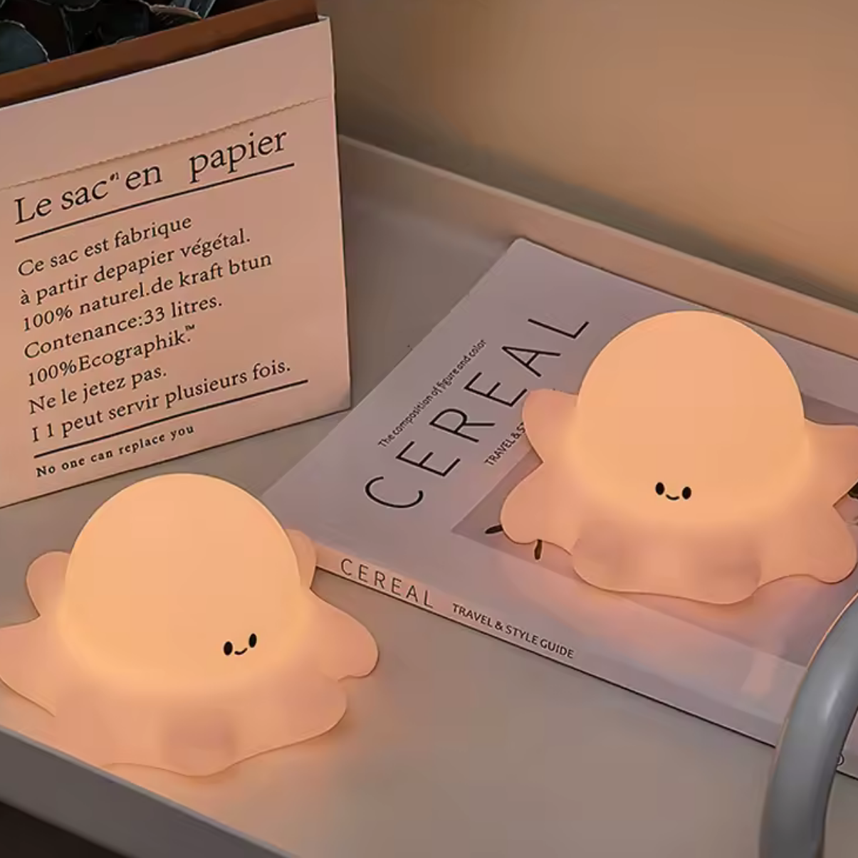 Two kawaii octopus night lights on a shelf next to books