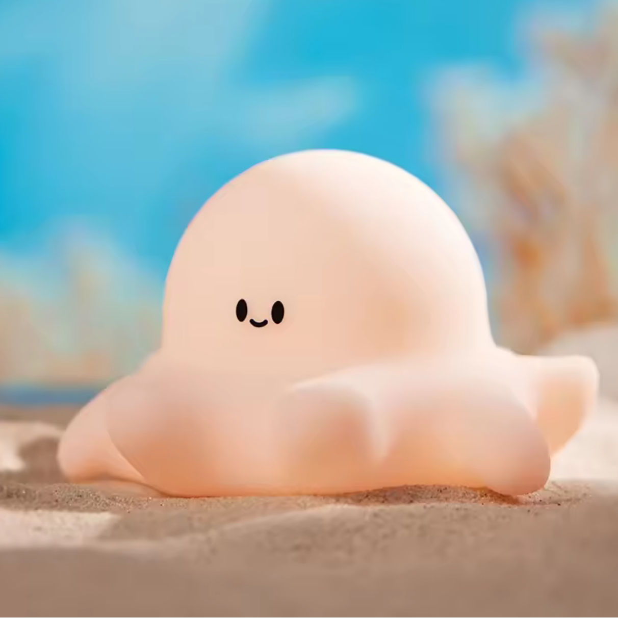 A happy looking kawaii octopus night light on sand
