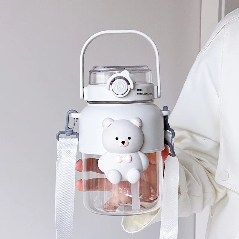 Clear kawaii water bottle with a white bear design held by a person wearing a white coat.