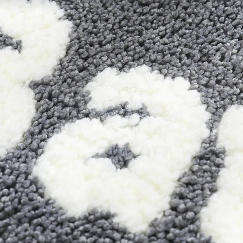 Close-up of a textured gray and white kawaii rug with geometric pattern