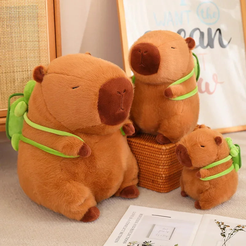 Three brown kawaii plush toys with green straps on a surface.