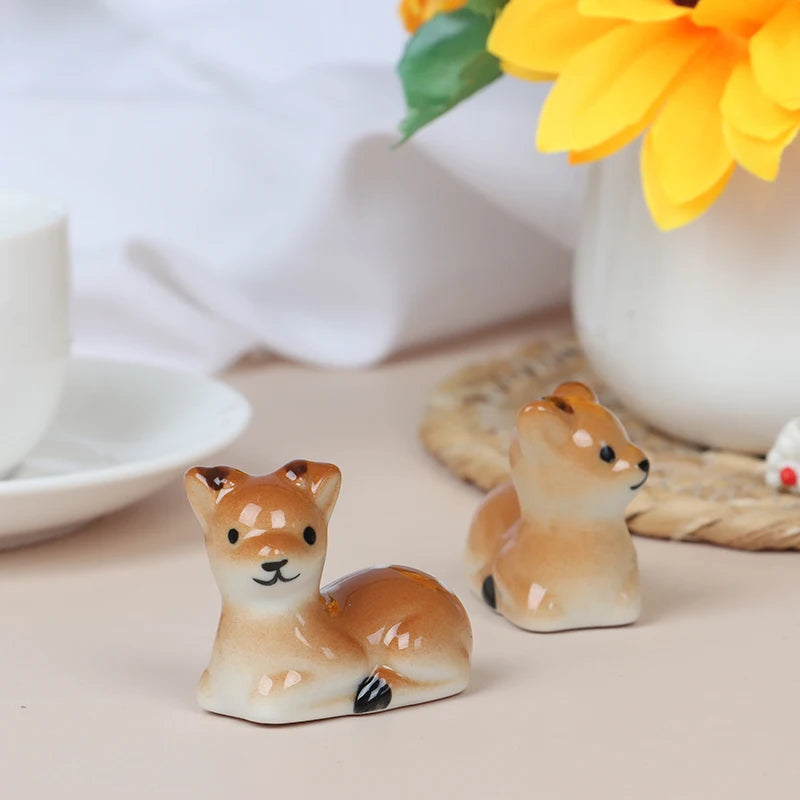 Two ceramic deer kawaii chopstick holders on a table with a blurred background