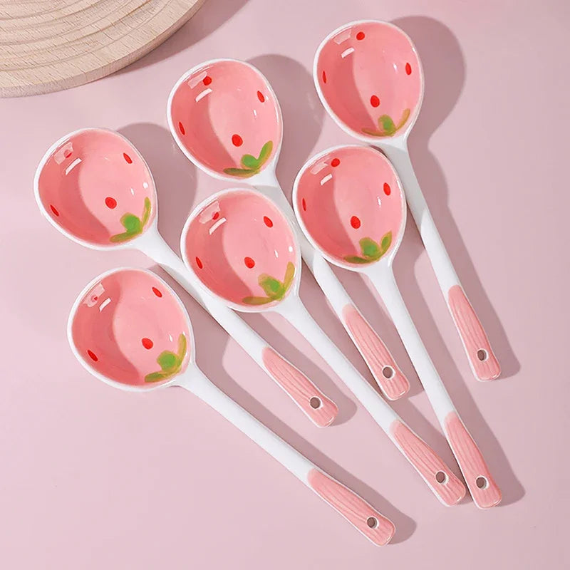 Six strawberry designed kawaii spoons on a pink background