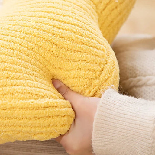 Yellow textured kawaii cushion held by a hand wearing a beige sweater.